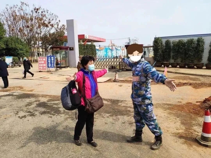 ·出院时，一位现场组织患者出院的军队工作人员看到母亲瘦弱的身躯，主动帮母亲拿行李，母亲感动异常，让病友帮忙拍下了这张“隔空拥抱”的珍贵照片。