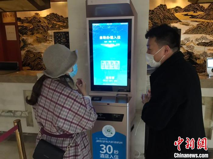     浙江宾馆推出“无接触”服务，顾客只需30秒就能快速办理入住。　严格　摄