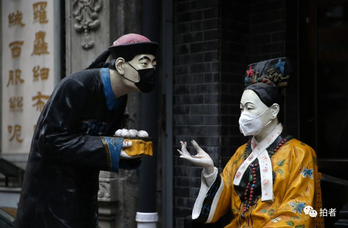  △&nbsp;2月29日，大栅栏商业街，路边的塑像被人戴上了口罩。摄影/新京报记者薛珺