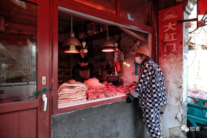  △&nbsp;2月22日，大栅栏社区内，居民戴口罩挑选商品。摄影/新京报记者王嘉宁