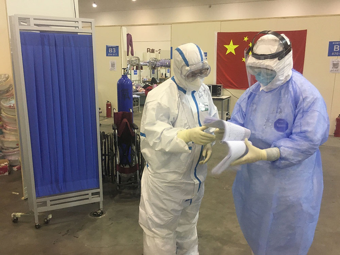 李昕（蓝衣者）在和上一班的医生交班。