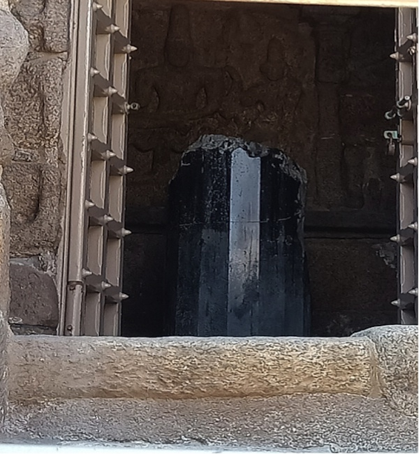 海岸神庙东殿内破裂的十六棱林伽，背后是苏摩室犍陀浮雕。