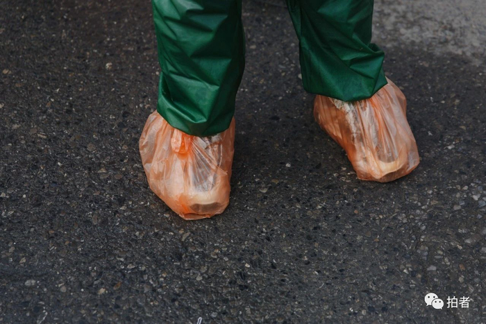 △&nbsp;2月25日，一名包裹严实的返京人员给鞋子套上了塑料袋。