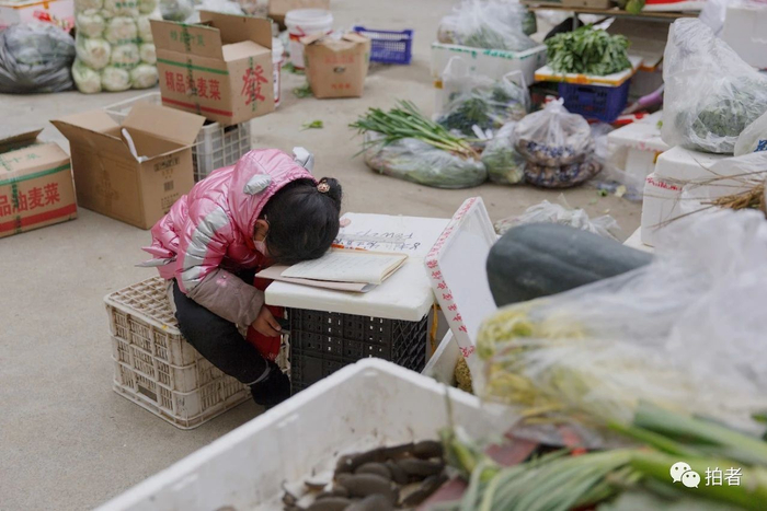△&nbsp;2月25日，一名跟着母亲在露天空地卖菜的女孩。