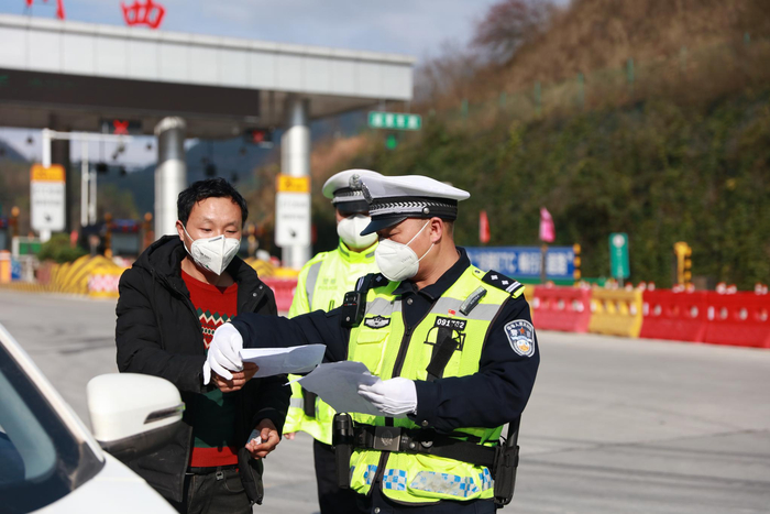 交警向永胜在检查司机的出入证件。受访者供图