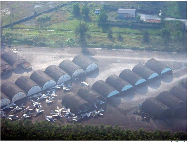 图片：越南岘港空军基地附近仓库外堆满米格战机，犹如飞机坟场。