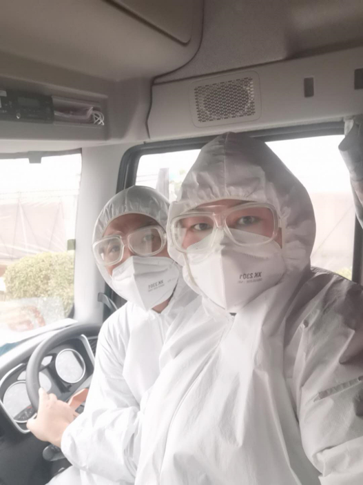 卡友秋姐和李哥身穿防护服运送物资