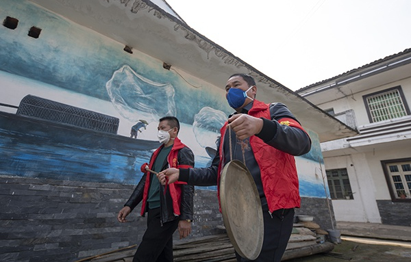 江西省新余市仙女湖区河下镇值守党员志愿者分组进村入巷，利用小喇叭、流动音箱、鸣锣等方式提醒村民戴口罩、排查串门聚众，引导群众加强防护。连日来，为控制人员流动、抑制疫情扩散，江西省新余市通过城乡拉网式排查和宣传，做到应查尽查，应报尽报，将人员流动风险降到最低。赵春亮摄
