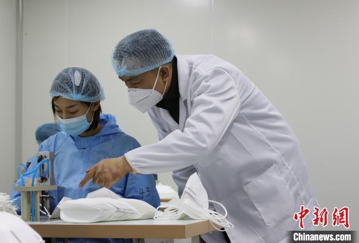 关勋泽到车间指导员工生产口罩。中新社记者 于海洋 摄