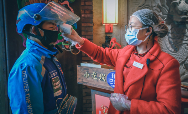 蜂鸟骑手在小龙坎门店取火锅外卖时检测体温