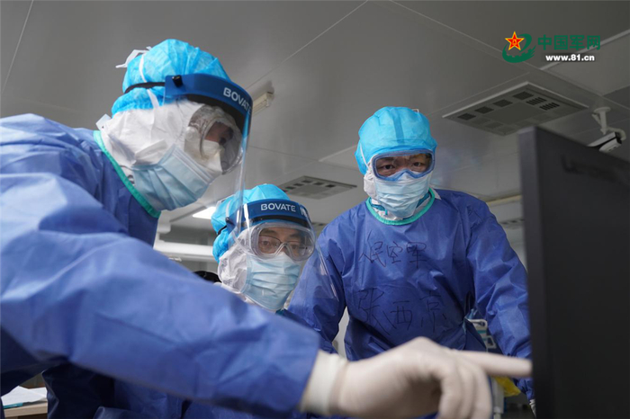 张西京（右一）与专家组成员研讨患者治疗方案。