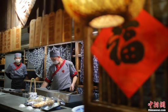 资料图：3月4日，南京大牌档金茂汇店的大厨正在烹制美食。 泱波 摄
