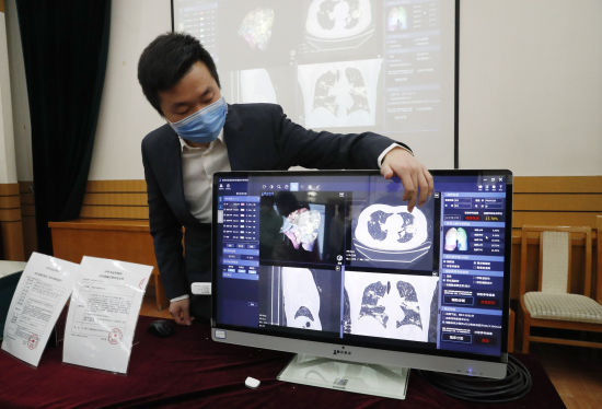 　　清华大学精密仪器系博士生王博介绍新型冠状病毒AI定量辅助诊断系统。（摄影：中新社记者 韩海丹）