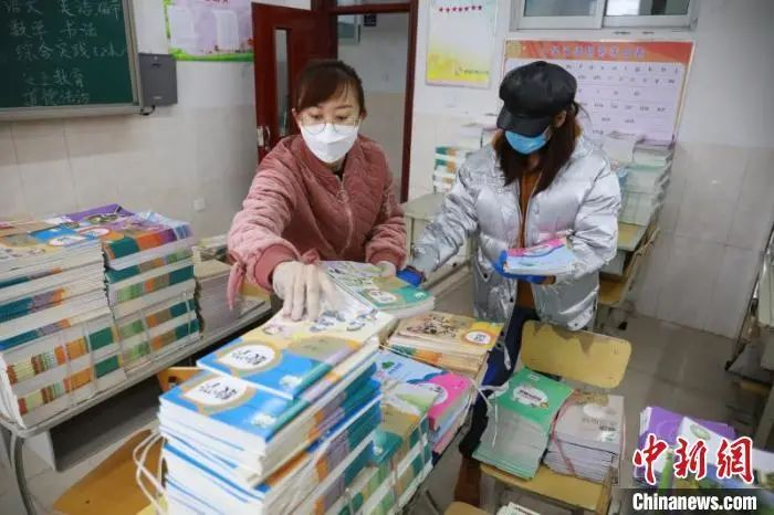 资料图：老师们分类整理新学期教材。　李捷 摄