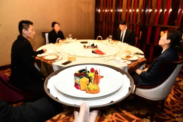 中国餐饮消费经历低谷后正在逐步复苏。图为3月26日，在山东舜和国际酒店，工作人员为客人上分餐。新华社发