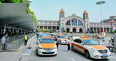 4月8日，在武汉汉口火车站前，旅客们排队乘坐出租车。新华社记者&nbsp;王毓国摄