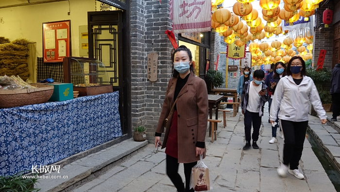  小镇街巷里漫步的游客。胡晓梅 摄