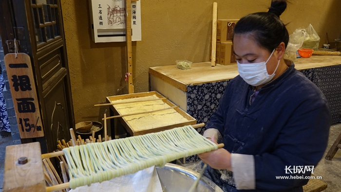  店员在认真制作一根面。胡晓梅 摄