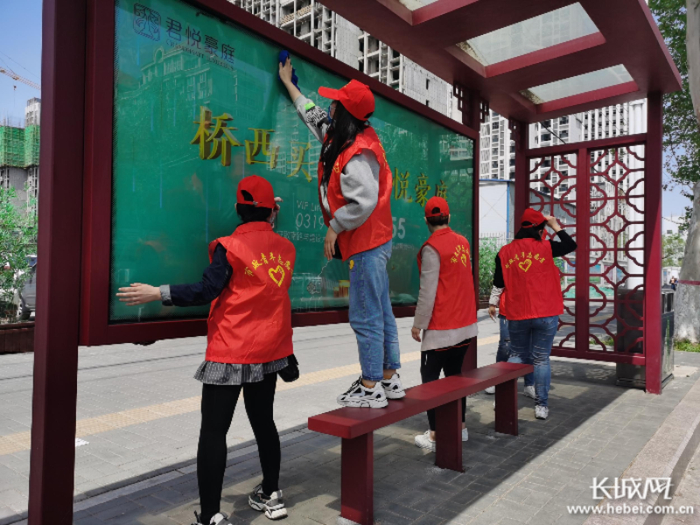 邢台市政建设集团志愿者擦洗公交站台。 张东青 供图