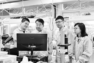     黄维（左二）在指导学生做实验。资料图片