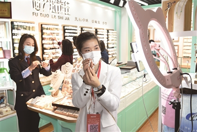 4月26日，在国际商贸城一区经营饰品的经营户正通过视频平台直播卖货。（龚献明 摄）
