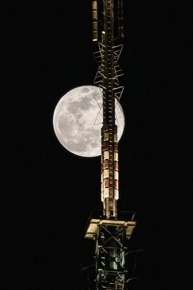 (4月8日,超级月亮从重庆电视台信号塔上升起)