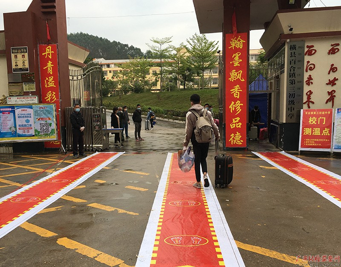 横县百合镇第三初级中学学生沿着标识进校门  （摄影  周振标）