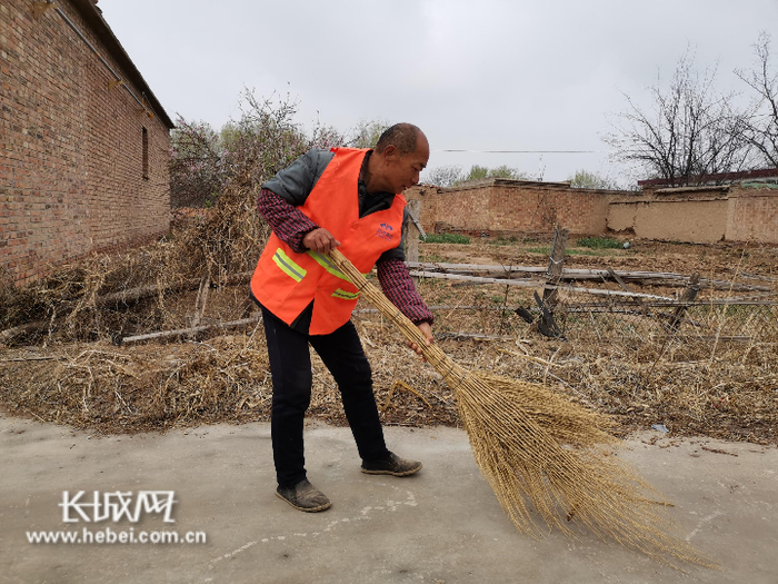 　周兰柱在村里做卫生保洁。樊加伟 供图
