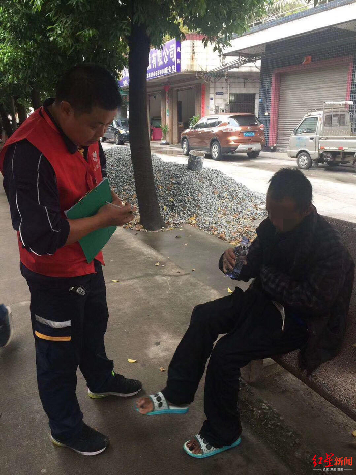 ↑志愿者（左）与流浪者曹某沟通。