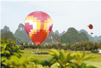 游客在桂林阳朔燕莎滑翔基地体验热气球和滑翔伞。 刘教清摄（人民视觉）