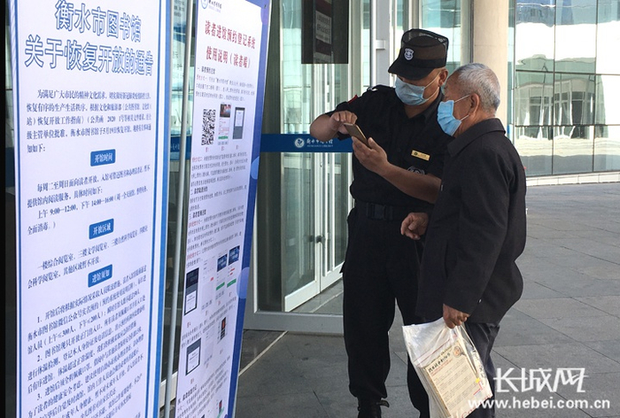 工作人员帮助老人在手机上进行实名预约。实习记者卢婉凤 摄