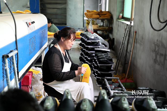 当地村民在该厂工作。长城新媒体记者 张晨光 摄