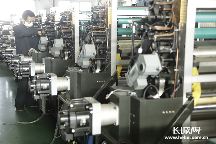 万杰公司工人正在组装标签印刷机。李洋摄