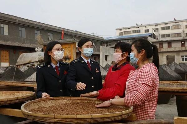 图为邳州市税务干部向当地农户宣传税费优惠政策。