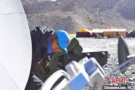24日，在西藏日喀则市定日县珠峰（珠穆朗玛峰）登山大本营，由西藏自治区气象局选派的预报服务团队成员在调试卫星天线。中新社发 洛桑 摄