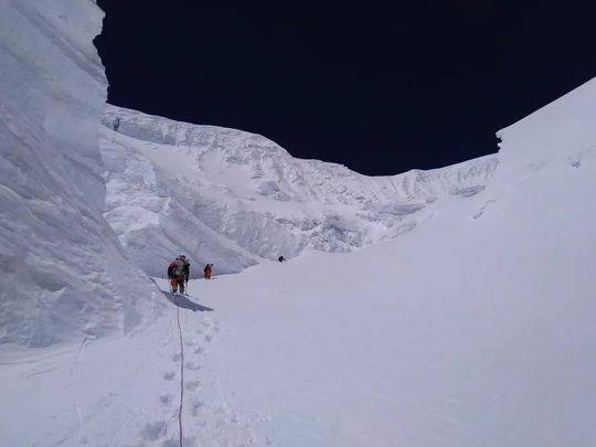 资料图：2020珠峰测量登山队的修路队员固定铺设在北坳冰壁上的路绳。巴桑塔曲 摄 图片来源：中国登山协会