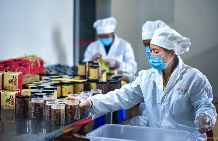 宾阳县新圩镇上国村的村民正在红糖产业实验示范基地包装红糖产品