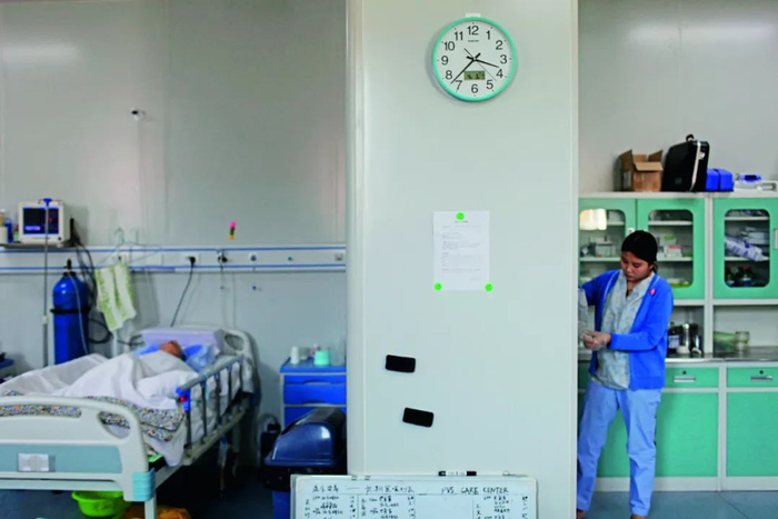 护士在病房内给病人准备食物。摄影/张涛