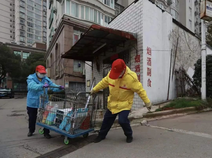 胡兰兰和同事拉着小车给附近的社区送货（图片来源：中国石油报）