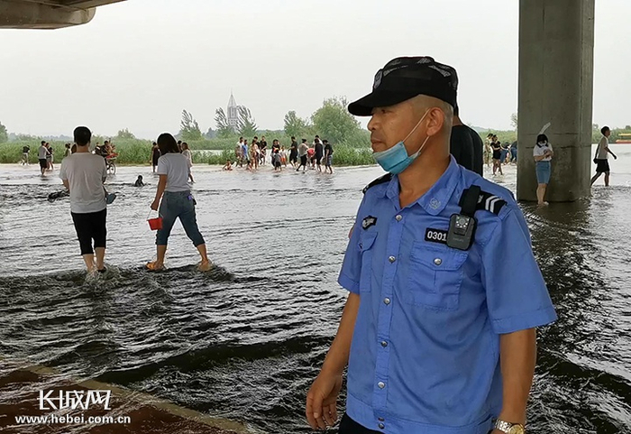 治安巡逻队队员董海龙在子龙大桥下劝阻戏水的人们。长城新媒体记者 周亚彬 摄