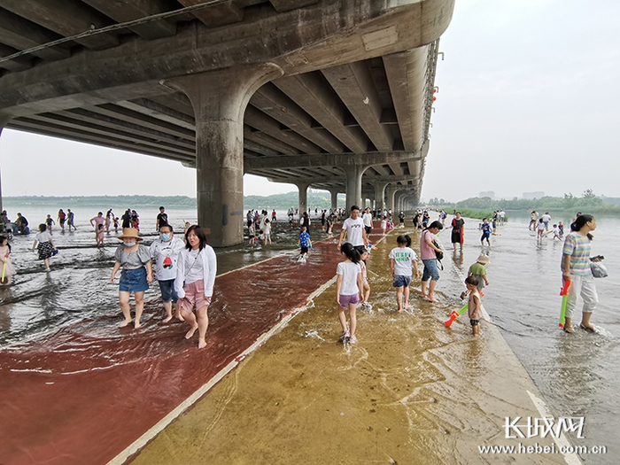 记者看到有许多家长带着孩子在漫水路上嬉戏打闹。长城新媒体记者 周亚彬 摄