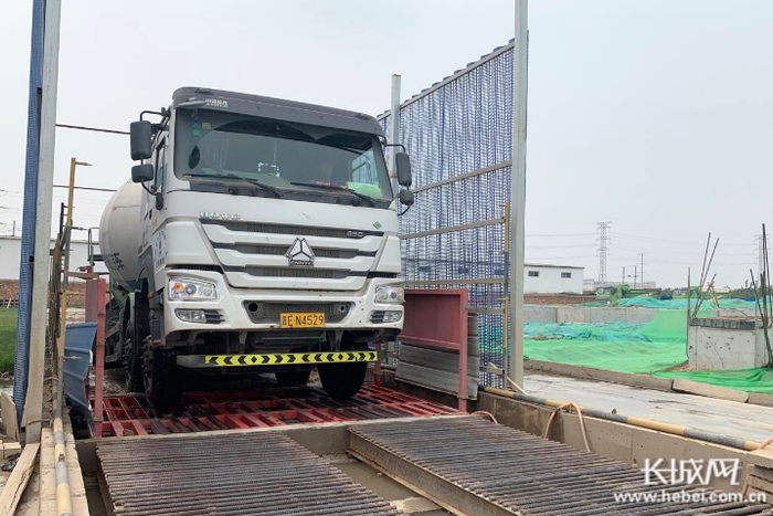 邢台晶龙新能源有限责任公司年产12000吨单晶硅棒项目施工现场设计了喷雾和清洗装置。 记者 胥文燕 摄