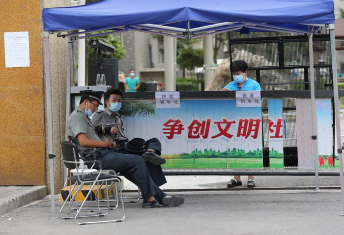 6月15日，北京新发地市场周边一小区出入口，工作人员在值守。（中国日报记者 张威 摄）