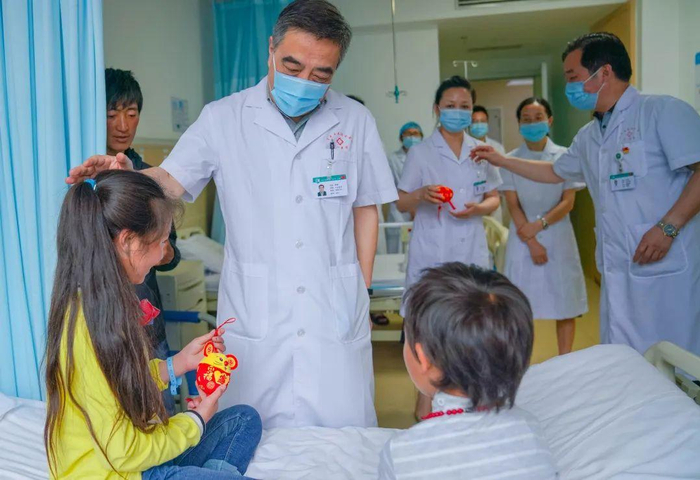 ▲院班子成员为孩子们送上吉祥物