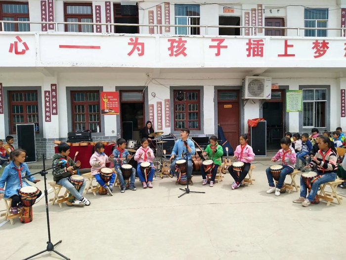 顾亚在学校里带领学生打鼓表演。受访者供图