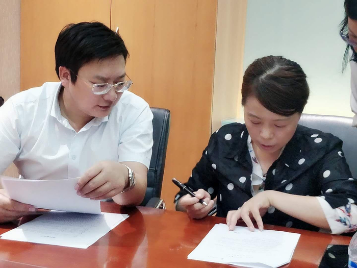  ▲周兆成律师（左）与许女士签订授权委托书。受访人供图
