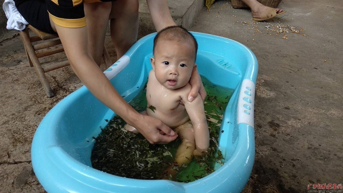 洗药浴，驱五毒。江州区民间一直都有端午日洗药浴的习俗，图为板利乡渠麻村渠麻屯村民用煎蒲、艾叶、薄荷等香草药给家里的小孩熬汤洗浴，可以驱赶苍蝇、蚊虫、蜈蚣等毒虫。