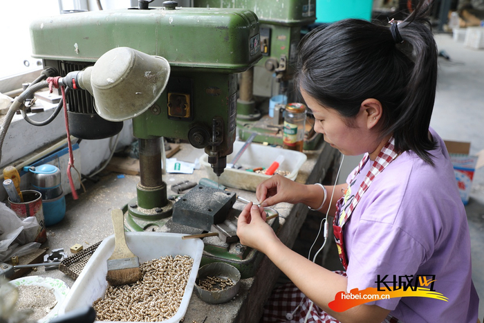 工人在乐器配件加工扶贫车间制作乐器零件。