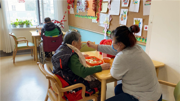 沈阳南十社区项目，照护师帮助老人用餐