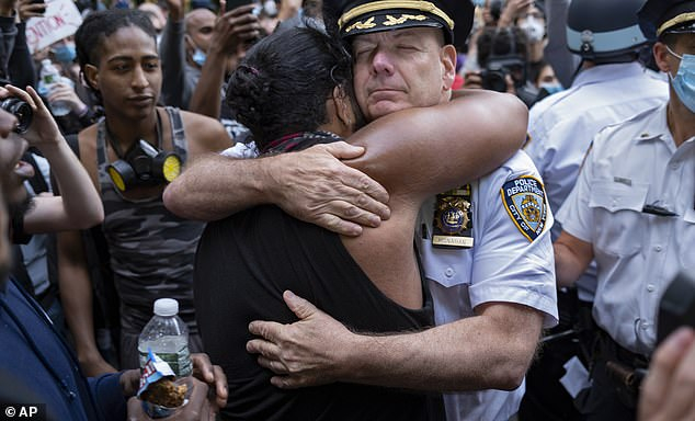  纽约市警察局局长特伦斯·莫纳汉与抗议者拥抱。（图源：AP）